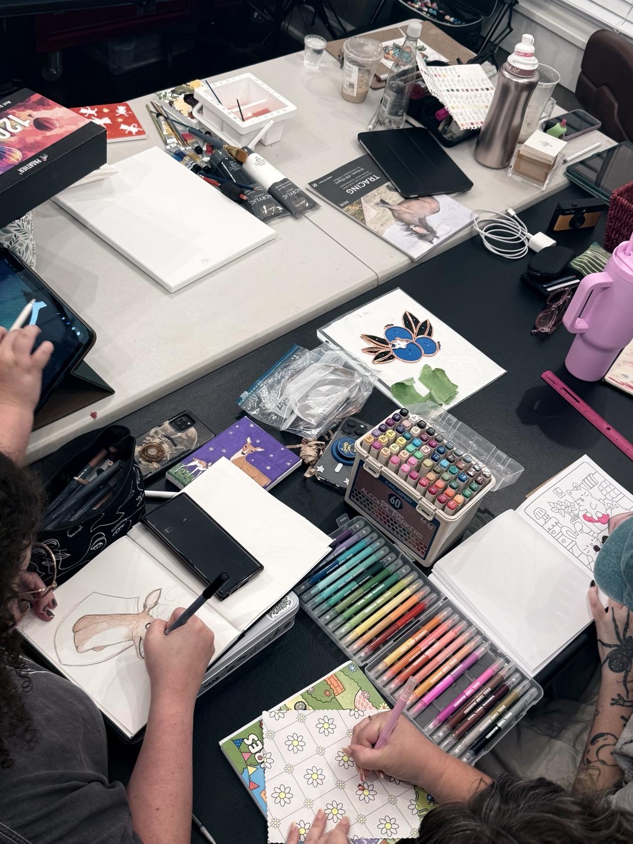 Participants sketching and drawing together at a work table